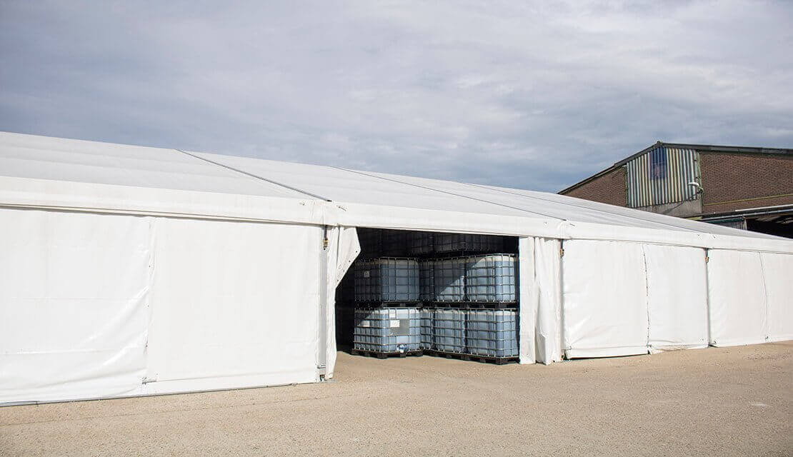 Engineered clear-span temporary storage facility with secure access and covered equipment storage